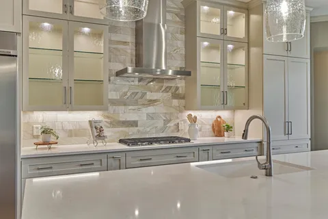 a large white kitchen with a large island oven in it