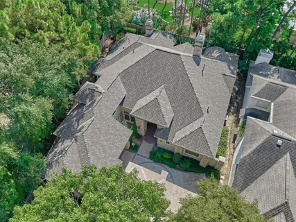 an aerial view of a house with a yard and large trees