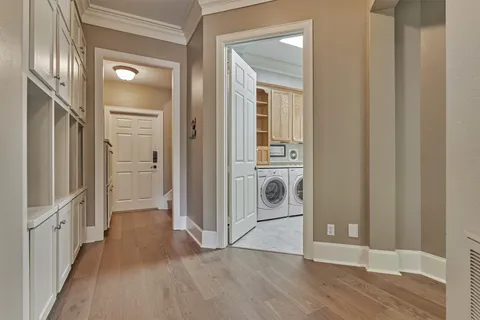 a view of a hallway with wooden floor and entryway