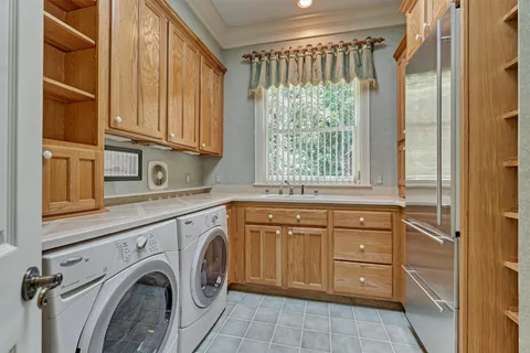 a utility room with granite countertop a sink a washer and dryer next to a window