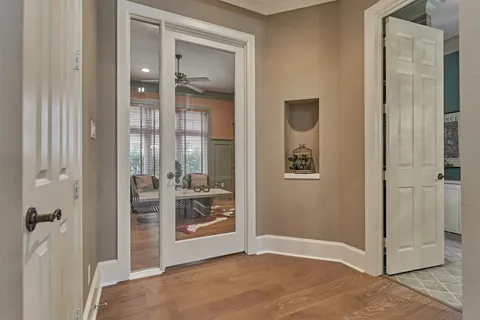 a hallway with wooden floor windows and entryway