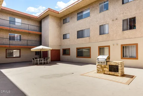 a building with table and chairs under an umbrella