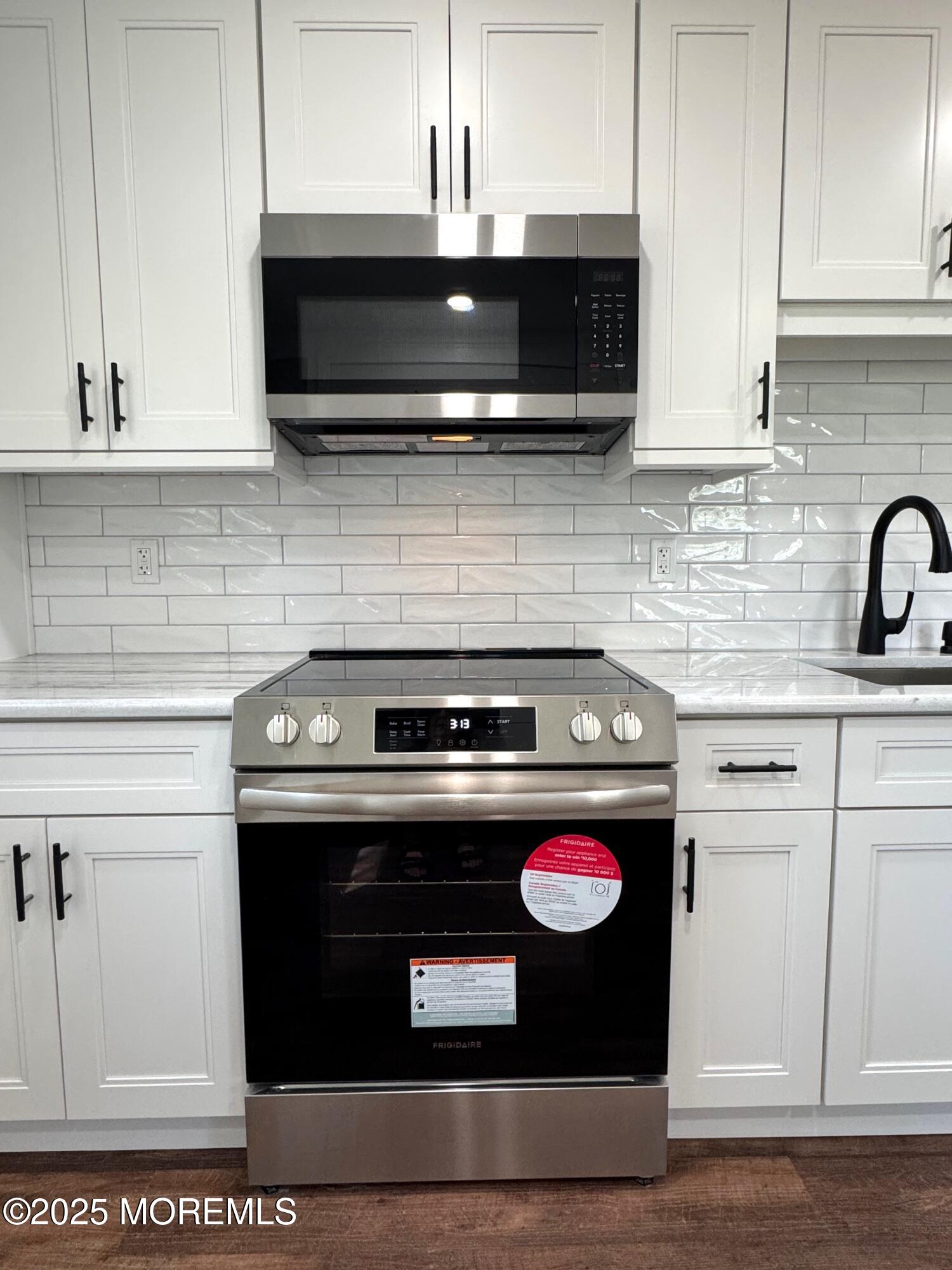5 Nevada Drive Whiting, NJ 08759 - Photo 10 of 44 a kitchen with microwave a stove and cabinets