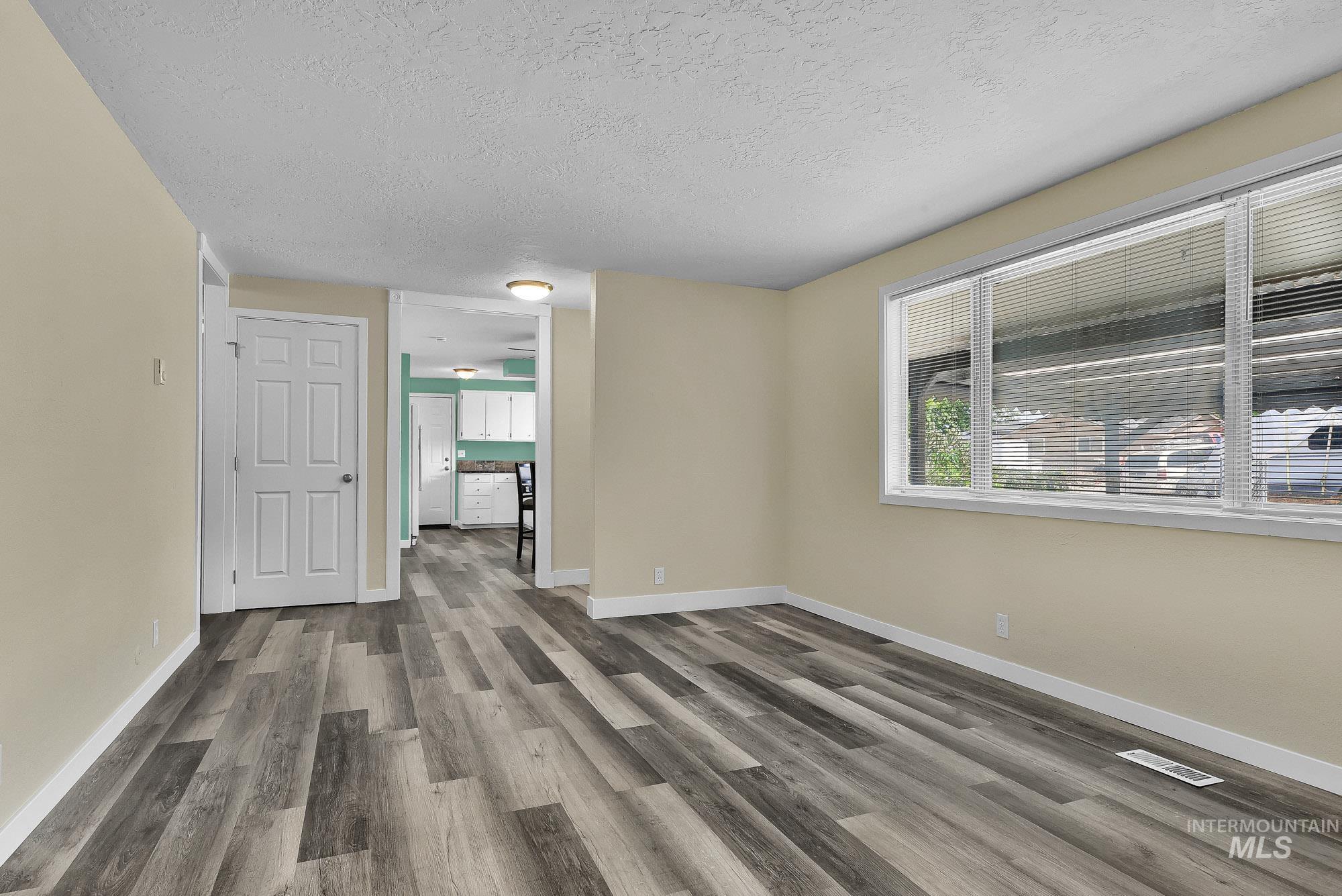 5755 Chuckwagon Road Nampa, ID 83686 - Photo 10 of 50 Wood-finish flooring throughout, light-toned wall paint, and multiple windows with blinds