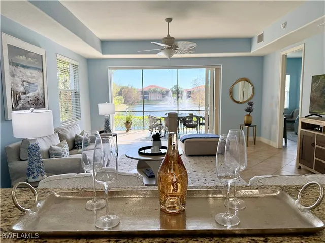 a view of a dining room with furniture a chandelier and large windows