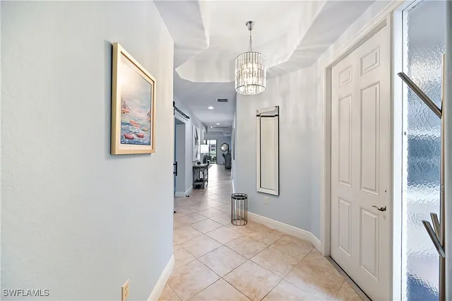 a view of a hallway with wooden floor and chandelier