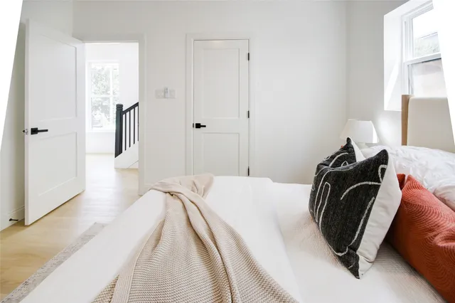 a bedroom with a bed and wooden floor