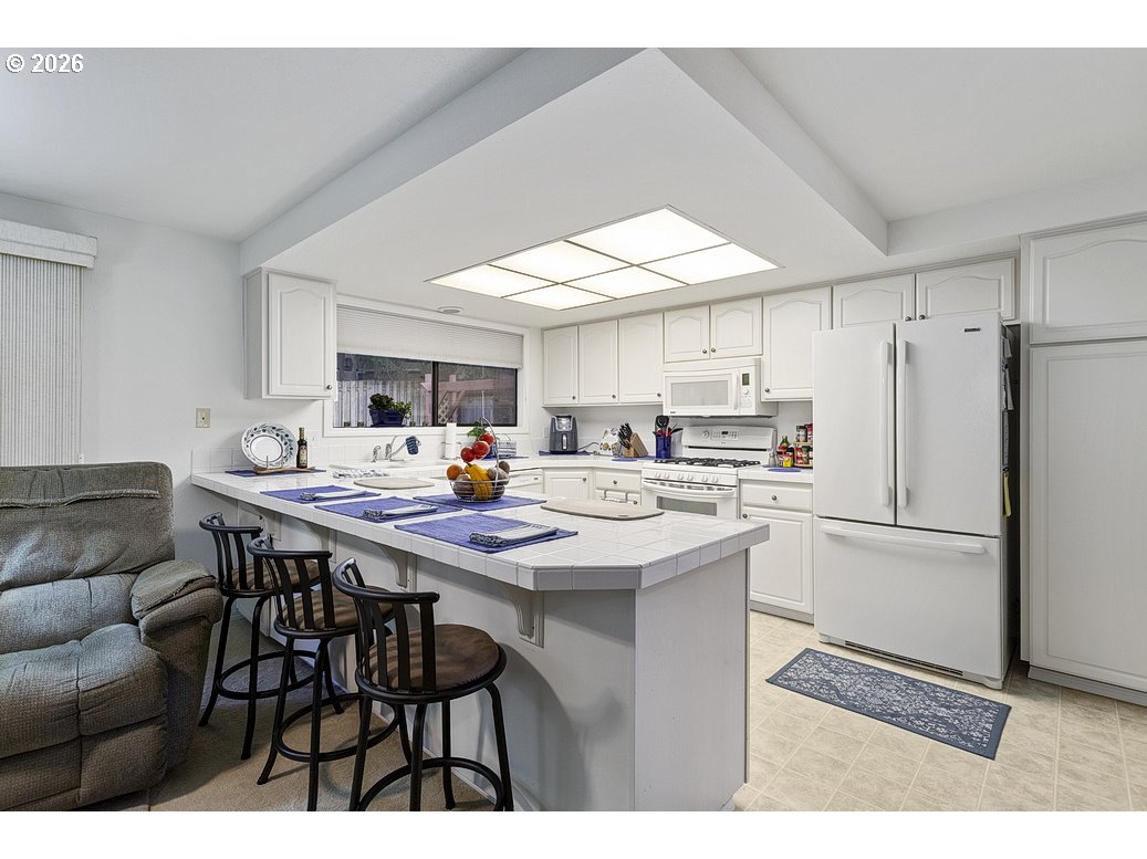 3788 Southeast 25th Street Gresham, OR 97080 - Photo 12 of 35 a kitchen with stainless steel appliances a table chairs and a refrigerator