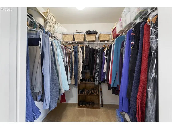 a view of walk in closet with clothes