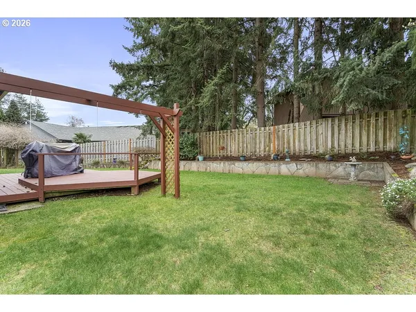 a view of a backyard with wooden fence and a bench
