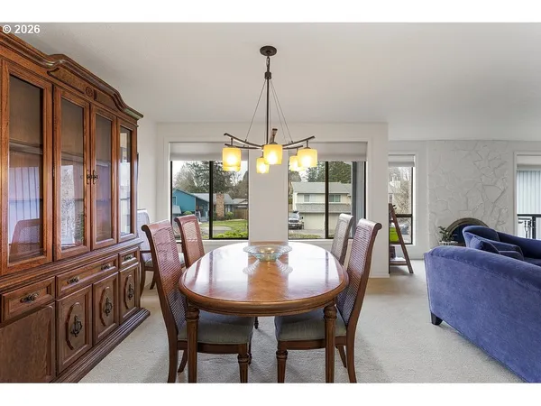 a dining room with furniture a chandelier and window