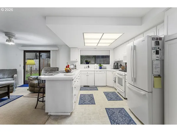 a kitchen with stainless steel appliances kitchen island granite countertop a refrigerator and a sink