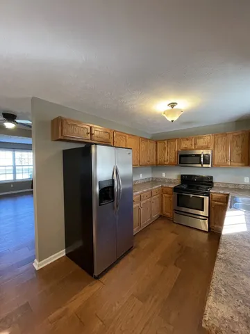 a kitchen with stainless steel appliances granite countertop a refrigerator and a stove
