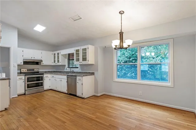 a kitchen with granite countertop a refrigerator and a stove top oven