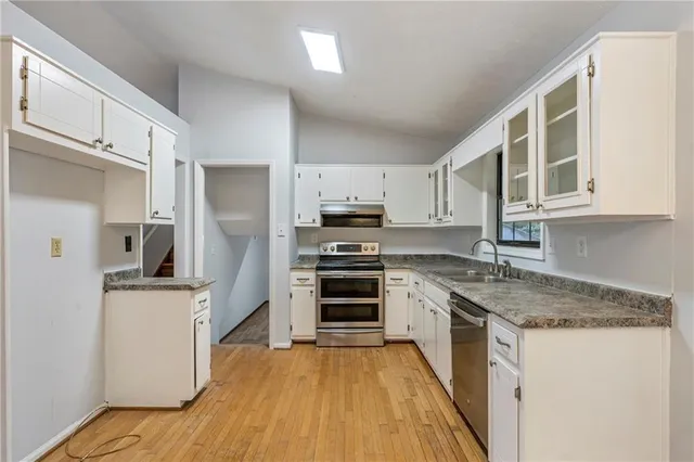 a kitchen with stainless steel appliances granite countertop a stove a sink and a microwave