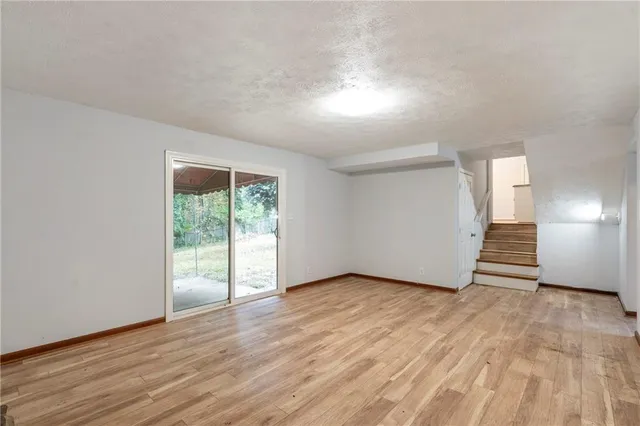 a view of empty room with wooden floor and fireplace