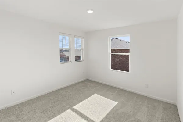 an empty room with windows and cabinet