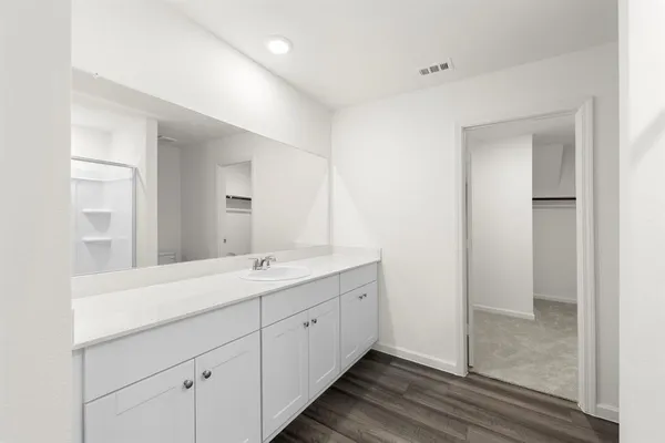 a bathroom with a granite countertop sink mirror and cabinets