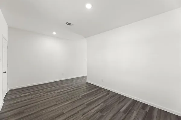 a view of an empty room with wooden floor