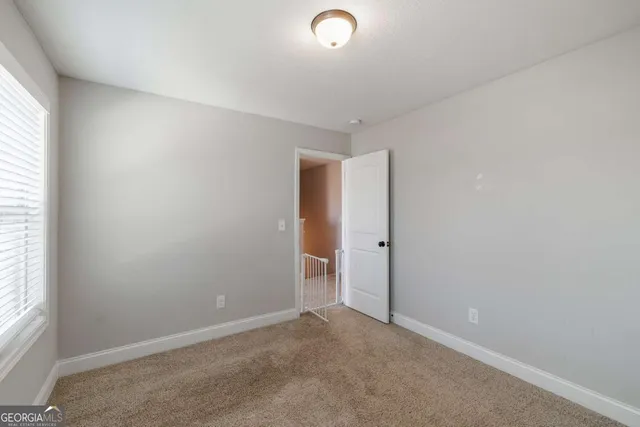 a view of a house with a yard and wooden bench