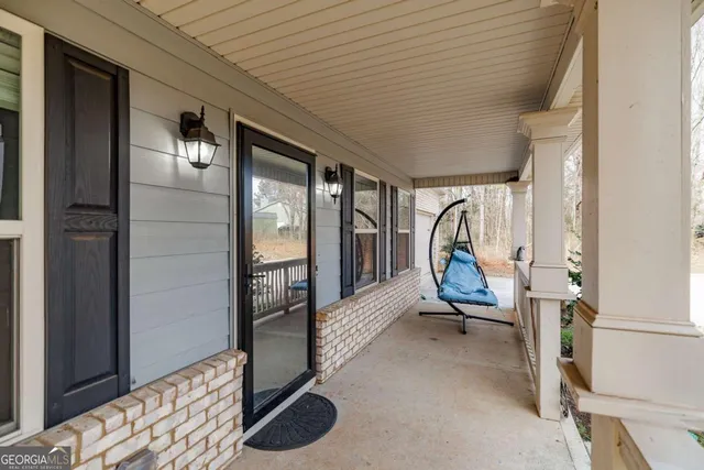 a view of a hallway with wooden floor and a bathroom