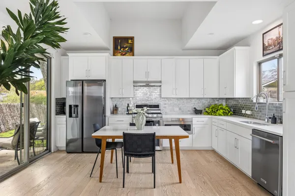 a kitchen with stainless steel appliances kitchen island granite countertop a refrigerator and a stove top oven