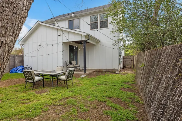 a backyard of a house with table and chairs