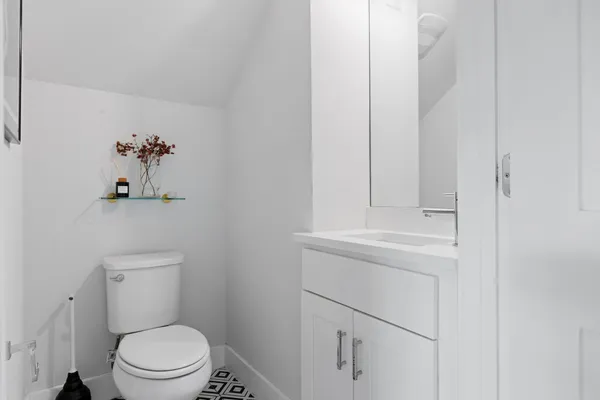a bathroom with a toilet a sink and mirror