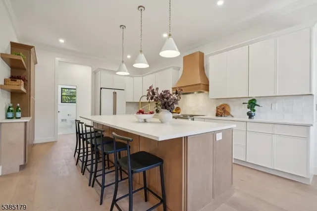 a kitchen with stainless steel appliances kitchen island a chandelier and cabinets