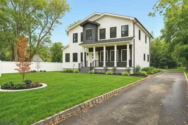 a front view of a house with a yard and green space