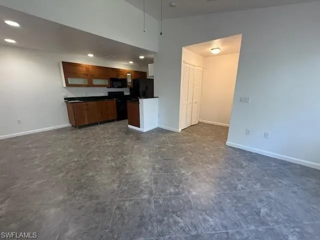 a view of an empty room with kitchen