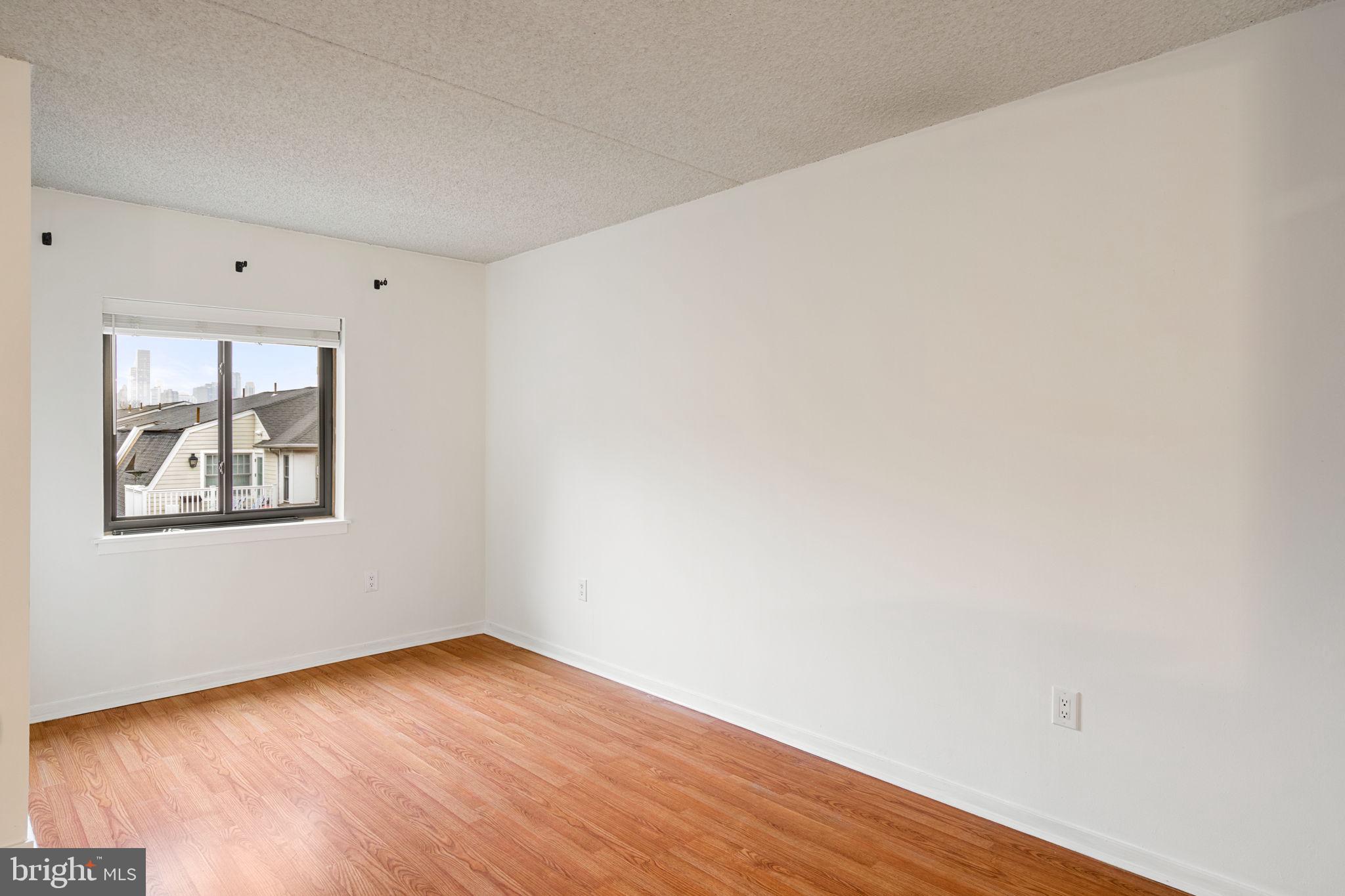 200 Lombard Street, Unit 602 Philadelphia, PA 19147 - Photo 11 of 32 a view of an empty room with wooden floor and a window