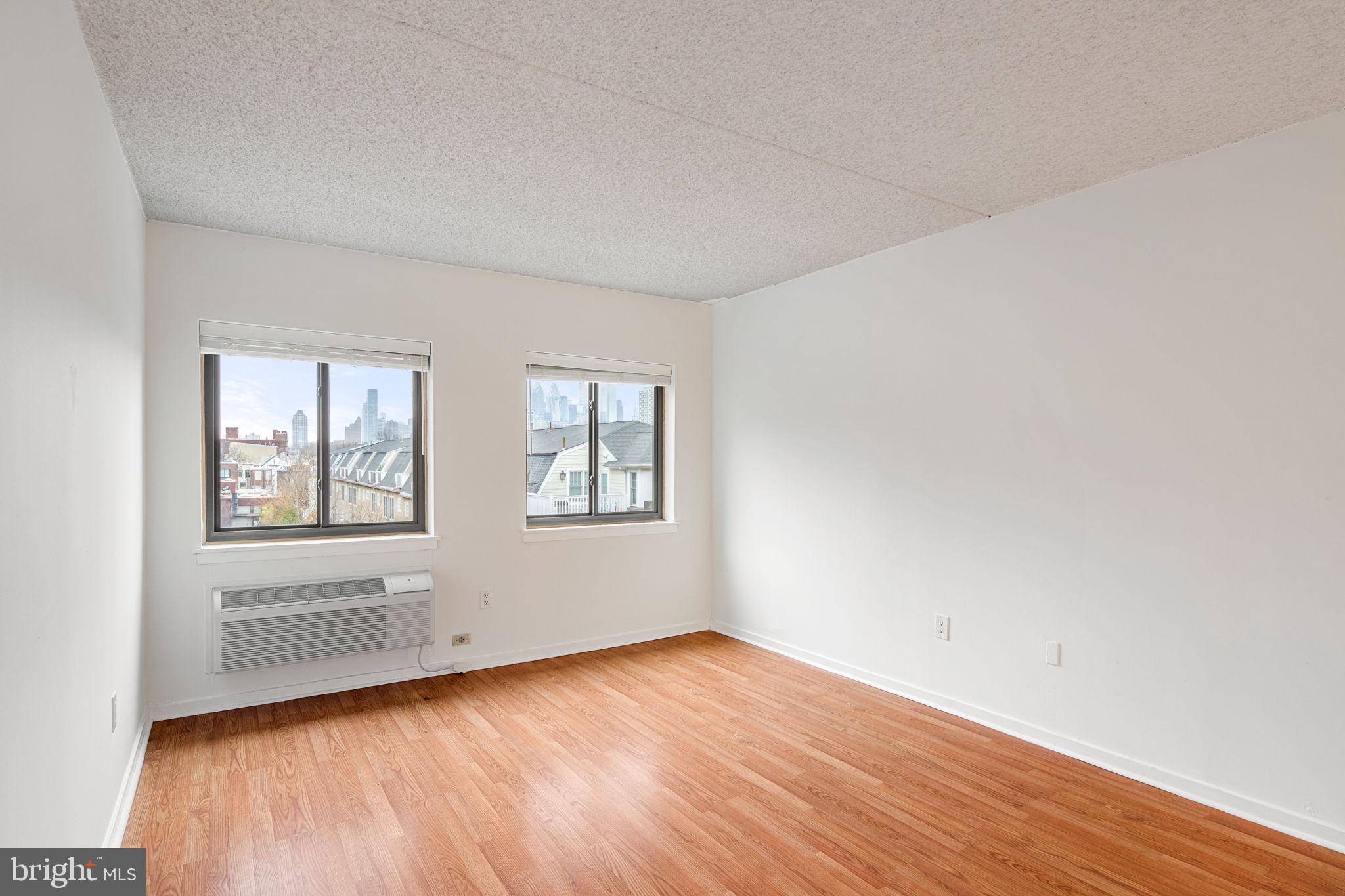 200 Lombard Street, Unit 602 Philadelphia, PA 19147 - Photo 19 of 32 an empty room with wooden floor and windows