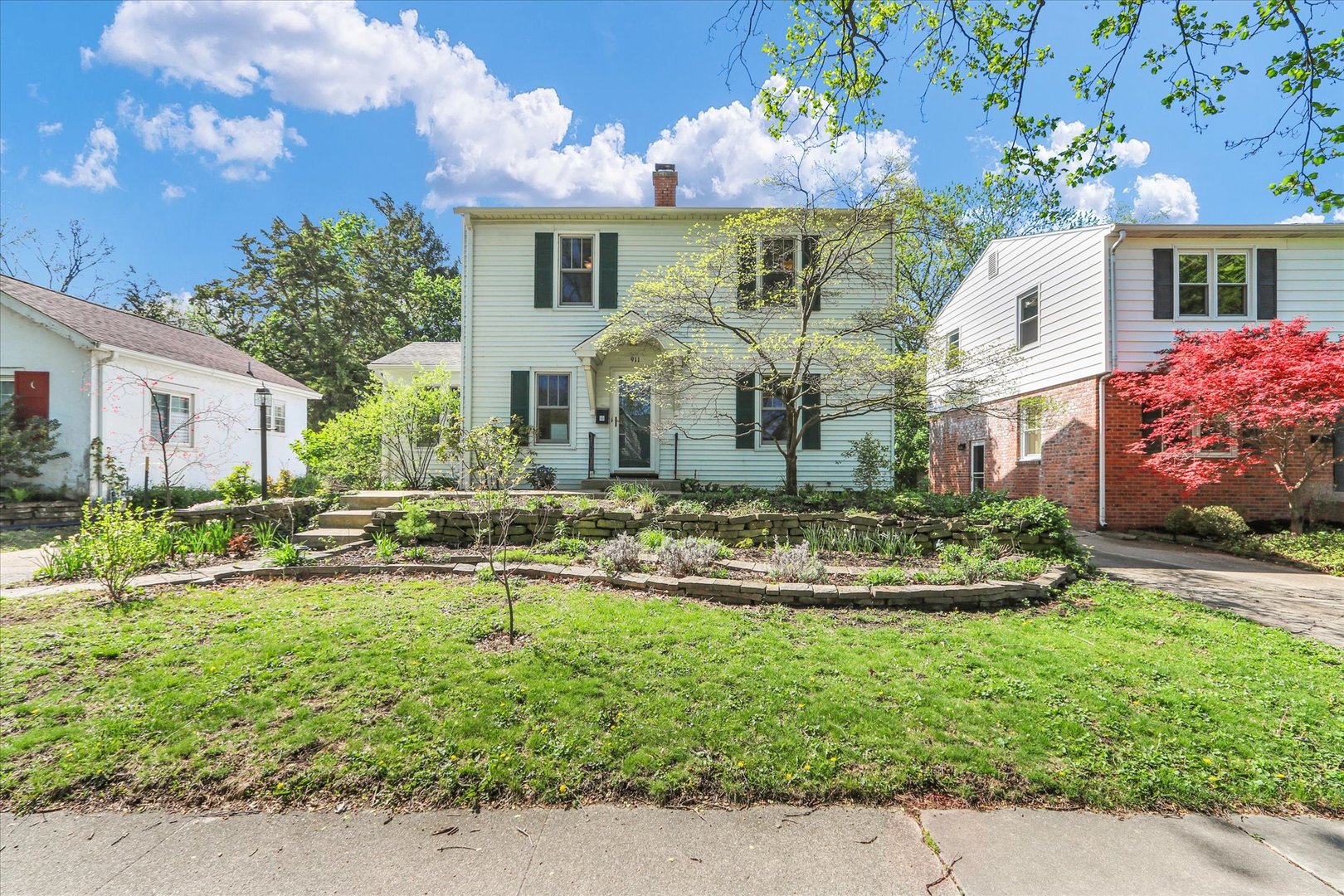 a front view of house with yard and trees around