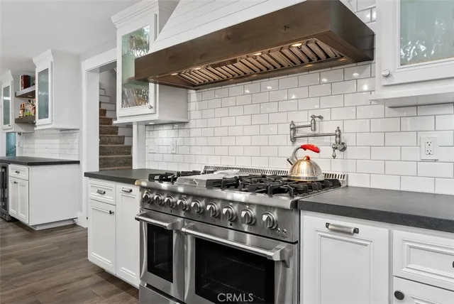 a kitchen with stainless steel appliances a dining table chairs stove microwave and refrigerator