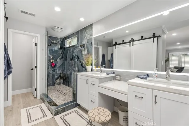 a bathroom with a double vanity sink mirror and shower