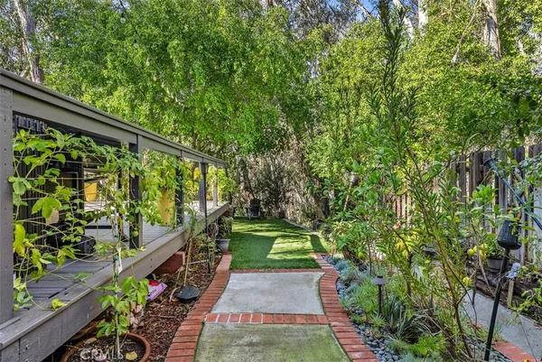 a view of a house with a small yard and a large tree