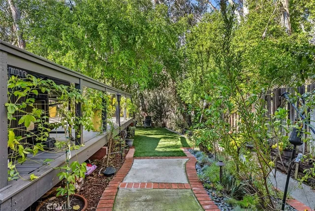 a view of a house with a small yard and a large tree