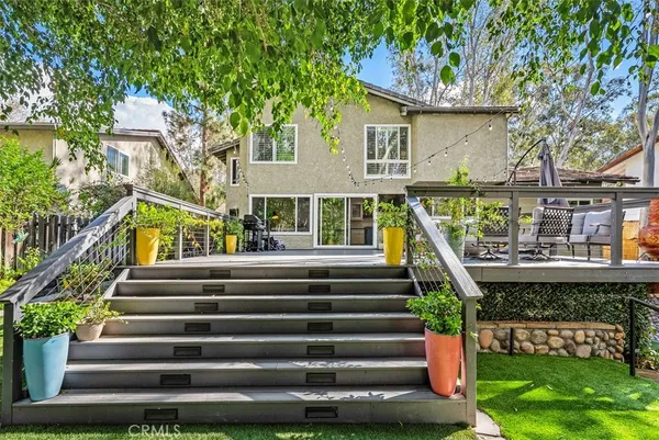 a view of a backyard with couches plants and wooden fence