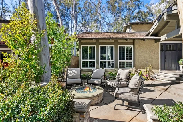 a view of a patio with couches table and chairs and potted plants
