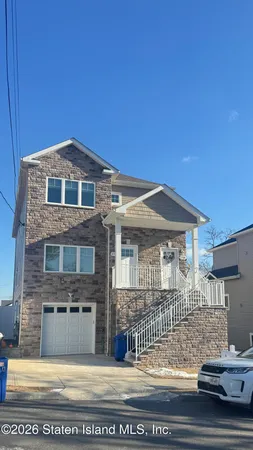 a large kitchen with kitchen island granite countertop a stove a sink a refrigerator white cabinets with wooden floor