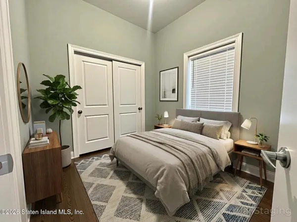 a bedroom with bed tv and window