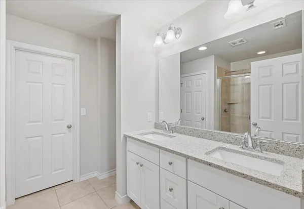 a bathroom with a granite countertop sink double and mirror