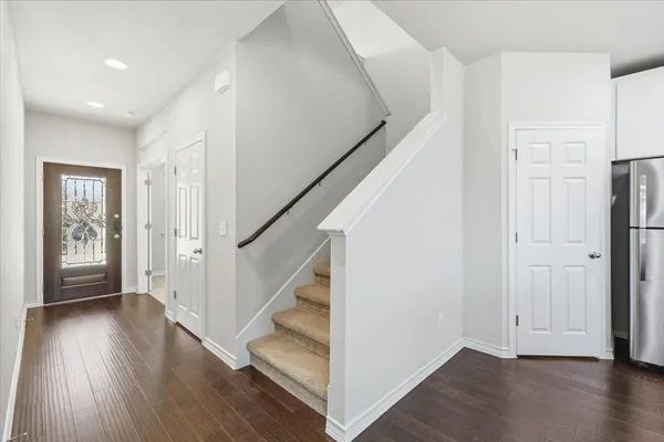a view of a hallway with wooden floor and staircase