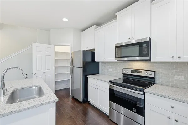 a kitchen with stainless steel appliances a stove microwave and sink