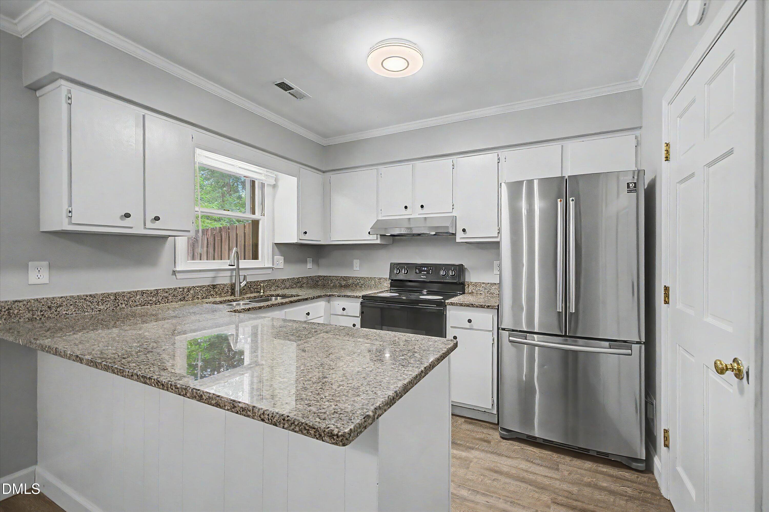 5519 Hamstead Crossing Raleigh, NC 27612 - Photo 13 of 33 a kitchen with granite countertop a refrigerator a sink a stove a microwave and island