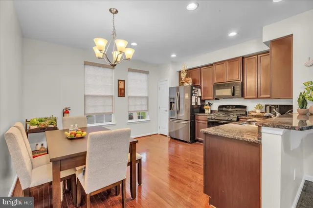 a view of a dining room with furniture a kitchen and chandelier