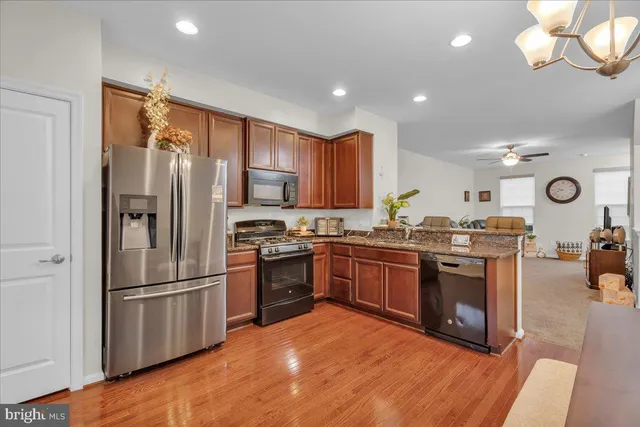 a kitchen with granite countertop stainless steel appliances and wooden cabinets