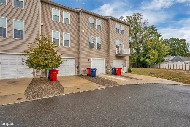 a street view with a building and trees in the background