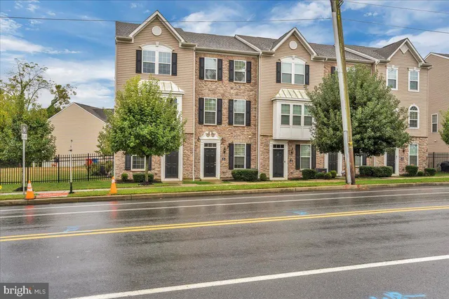 a view of a big house with a big yard and large trees